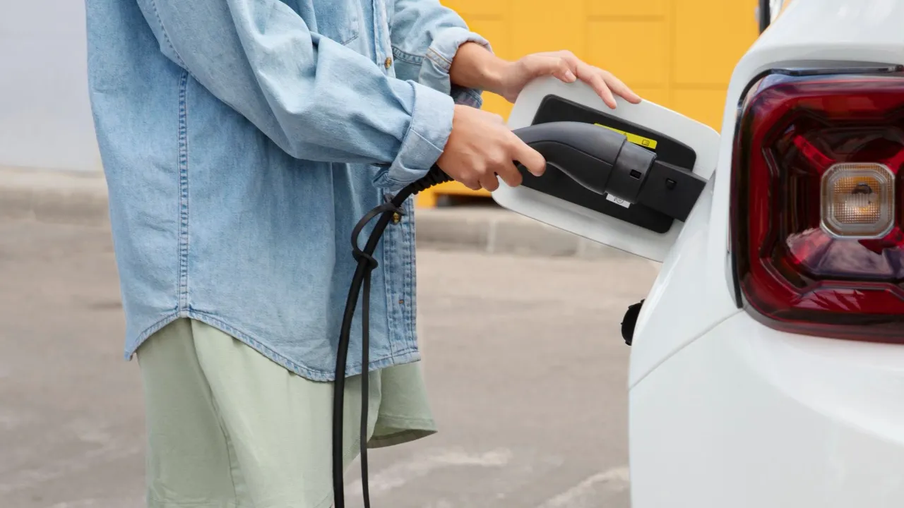 Pessoa conectando um carregador a um carro elétrico
